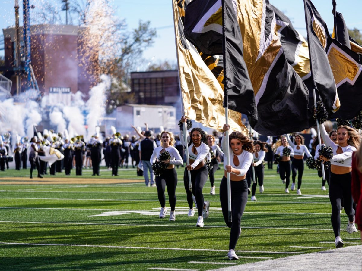 Cheerleaders run with Vanderbilt flags across the field as fireworks go off in the background, as photographed on Nov. 4, 2023. (Hustler Multimedia/Ophelia Lu)
